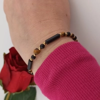 Modna biżuteria z kamieni naturalnych onyks i tygrysie oko elegancko zaprezentowana na nadgarstku modelki
