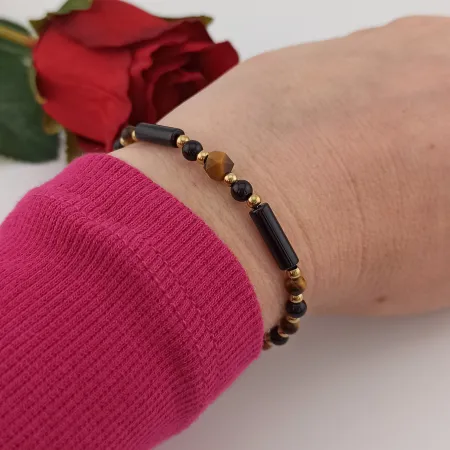 Modna biżuteria z kamieni naturalnych onyks i tygrysie oko elegancko zaprezentowana na nadgarstku modelki